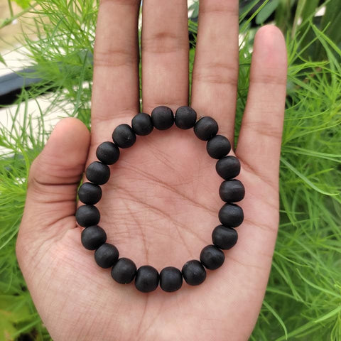 ghee baked tulsi beads bracelet on hand of a person