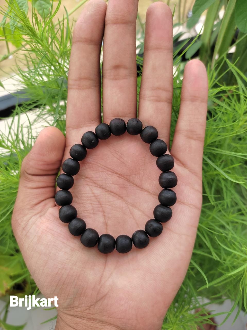 ghee baked tulsi beads bracelet on hand of a person